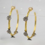 A pair of gold and diamond hoop earrings.