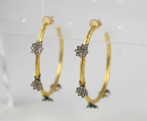 A pair of gold and diamond hoop earrings.