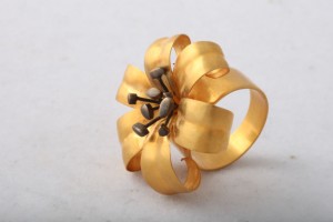 A gold ring with a flower design on it.