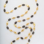 A long necklace with gold and black beads.