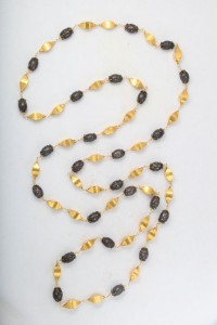 A long necklace with gold and black beads.