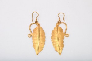 A pair of gold earrings with leaves hanging from them.