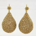 A pair of gold earrings with large, sparkling drops.