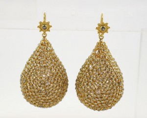 A pair of gold earrings with large, sparkling drops.
