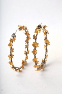 A pair of gold flower hoops with silver posts.