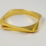 A gold ring with two intersecting sections on top of it.