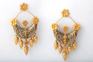 A pair of gold earrings with flowers and leaves.