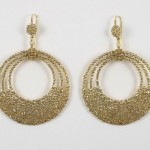 A pair of gold earrings with a circular design.