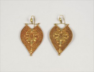 A pair of gold earrings with a heart shaped design.