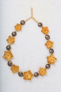 A necklace with gold and silver beads on it.