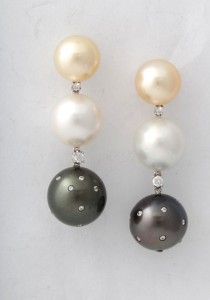 A pair of earrings with pearls and diamonds.
