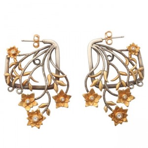 A pair of earrings with flowers and branches.