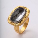 A gold ring with a large black stone on top of it.