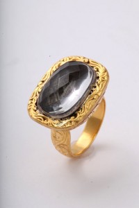 A gold ring with a large black stone on top of it.