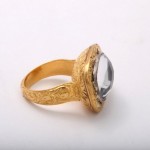 A gold ring with a large stone on top of it.