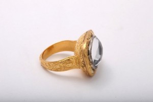 A gold ring with a large stone on top of it.