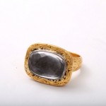 A gold ring with a black stone on top of it.