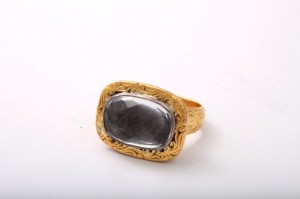 A gold ring with a black stone on top of it.