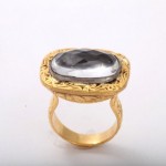 A gold ring with a large stone on top of it.