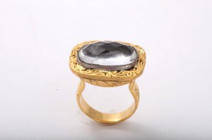 A gold ring with a large stone on top of it.