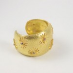 A gold ring with some small stars on it