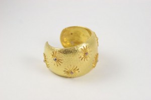 A gold ring with some small stars on it