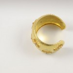 A gold ring with some small yellow flowers on it