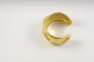 A gold ring with some small yellow flowers on it