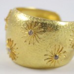 A gold bracelet with some flowers on it