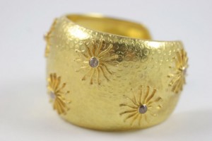 A gold bracelet with some flowers on it