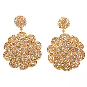 A pair of gold earrings with large round filigree design.