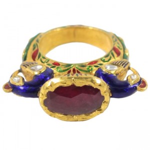 A gold ring with red stone and blue enamel.