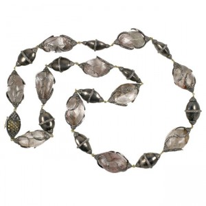 A long necklace of silver beads with a diamond shaped center.