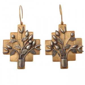 A pair of earrings with flowers in a vase.
