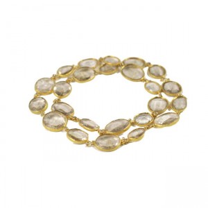 A gold necklace with clear stones on it.