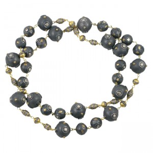 A long necklace with black beads and gold accents.