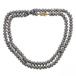 A long necklace of grey beads with gold clasp.