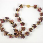 A necklace and bracelet set of purple flowers.