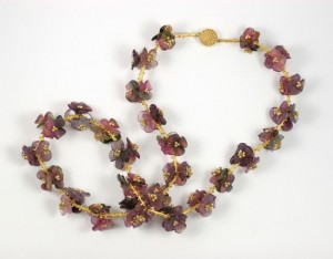A necklace and bracelet set of purple flowers.