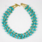 A necklace with three strands of turquoise beads.