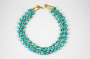 A necklace with three strands of turquoise beads.