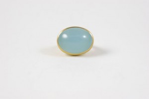 A blue stone is sitting on top of a gold ring.