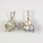 A pair of earrings with pearls and diamonds.