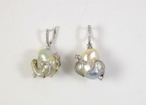 A pair of earrings with pearls and diamonds.