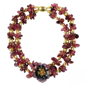 A necklace with two strands of beads and a flower.