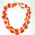 A long necklace of orange and gold beads.