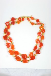 A long necklace of orange and gold beads.