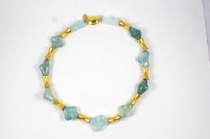 A necklace of green and blue stones with gold beads.