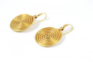 A pair of gold earrings with spiral design.