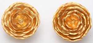 A pair of gold earrings with a flower design.